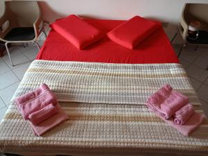 łóżko z dwoma różowymi poduszkami na górze w obiekcie Appartamento Santa Giusta w mieście Santa Giusta