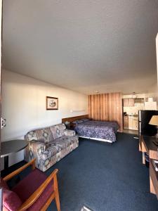 a hotel room with a couch and a bed at Howard Johnson by Wyndham Edson in Edson
