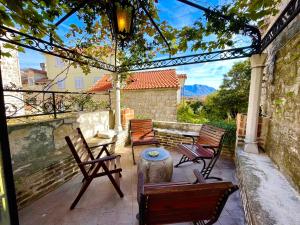 a patio with chairs and a table and a stump at Old town house with private garden in Budva