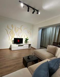 ein Wohnzimmer mit einem Sofa und einem TV in der Unterkunft Moon Apartment Tirana in Tirana