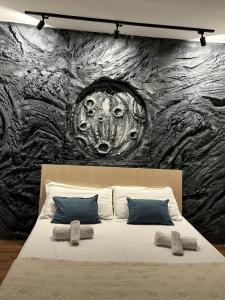 ein Schlafzimmer mit einer großen Steinmauer hinter einem Bett in der Unterkunft Moon Apartment Tirana in Tirana