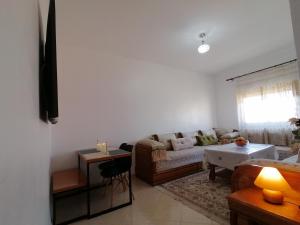 ein Wohnzimmer mit einem Sofa und einem Tisch in der Unterkunft Light appartement in Agadir