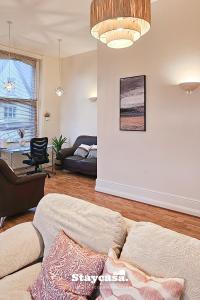 a living room with a couch and a table at Spacious Home In Whalley Range With Free Parking in Manchester