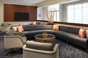 a living room with a couch and chairs and a tv at Courtyard by Marriott Ottawa Downtown in Ottawa