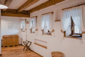 シモンにあるMATCA Transylvanian Sanctuaryの白い壁と木製の梁の窓が特徴の客室です。