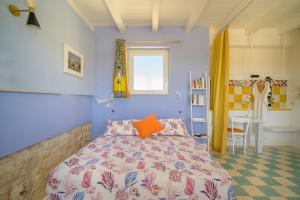 a blue bedroom with a bed and a desk at Casa Farlisa, antico baglio con piscina in Scicli +69 photos