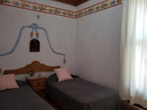 1 dormitorio con 2 camas individuales y ventana en Peña de Bernal Rancho La Trinidad, 
