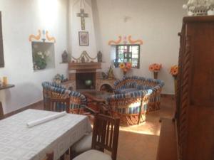sala de estar con mesa, sillas y chimenea en Peña de Bernal Rancho La Trinidad, 