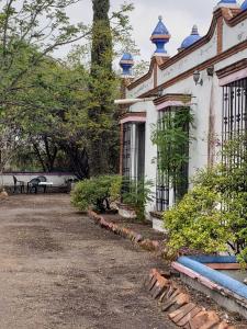 a white house with a bench in front of it at Peña de Bernal Rancho La Trinidad in Cerrito