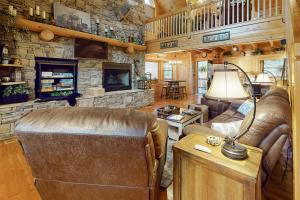 a living room with a couch and a stone wall at Copper Lantern in Ellijay