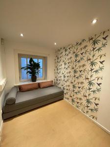 a room with a couch and a window with a plant at The Suites Alster Waterfront Family Apartments in Hamburg
