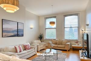 a living room with two couches and a table at Spacious Home In Whalley Range With Free Parking in Manchester