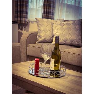 a bottle of wine and a glass on a coffee table at Seal Bay Resort in Selsey
