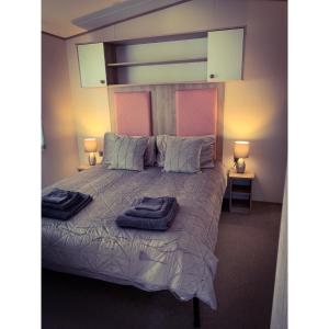 a bedroom with a bed with two towels on it at Seal Bay Resort in Selsey
