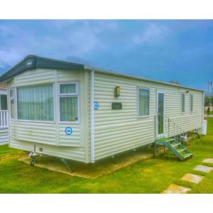 małą białą przyczepę na polu trawy w obiekcie Seal Bay Resort w mieście Selsey +22 zdjęcia