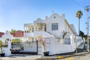 una casa bianca con una recinzione bianca davanti di Secure & Central: Villa with Views [2 bed both ensuite] a Città del Capo