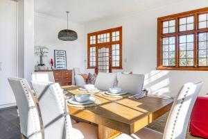 una sala da pranzo con tavolo e sedie in legno di Secure & Central: Villa with Views [2 bed both ensuite] a Città del Capo
