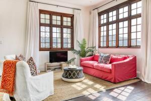 un soggiorno con 2 divani rossi e una TV di Secure & Central: Villa with Views [2 bed both ensuite] a Città del Capo