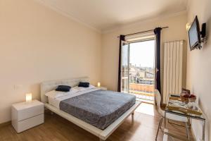 a bedroom with a bed and a large window at Bon Ton Suite in Rome