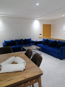 a living room with a blue couch and a table at Apartment chakira family only in Tangier