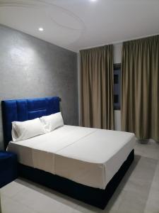 a bedroom with a large bed with a blue headboard at Apartment chakira family only in Tangier