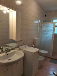 uma casa de banho com um lavatório, um WC e um chuveiro em Casa Licanio em Bibione