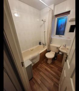 a bathroom with a tub and a toilet and a sink at Cosy 2 bed house in the heart of leyland in Leyland