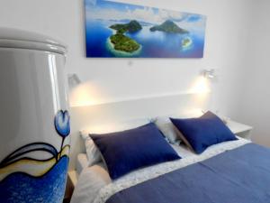 a bedroom with a bed with a painting on the wall at Casa Mirasol, WIFI y NETFLIX free in Playa Honda