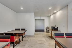 a waiting room with tables and chairs and a television at Motel 6 Ogden, UT- Downtown in Ogden