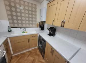 a kitchen with a sink and a dishwasher at Cosy 2 bed house in the heart of leyland in Leyland