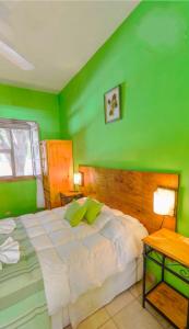 Dormitorio verde con cama y mesa en Apart Franchino en Mina Clavero