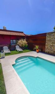 a swimming pool in front of a house at Apart Franchino in Mina Clavero