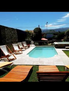 a swimming pool with lounge chairs and a group at Apart Franchino in Mina Clavero