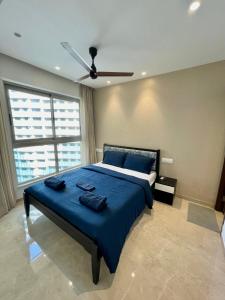 a bedroom with a blue bed with a ceiling fan at 1 BHK in Hiranandani Powai. in Mumbai