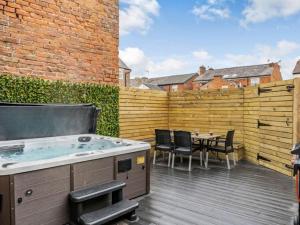 a hot tub on a deck with a table and chairs at Ashley Place in Southport