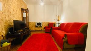 a living room with a red couch and a red rug at Alojamento CANTO NA RELVA in Ponta Delgada