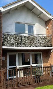 a house with a balcony on top of it at Waterside Villa in Corton