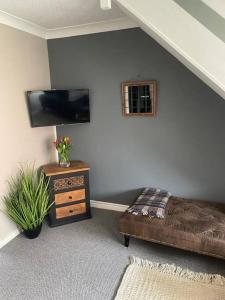ein Wohnzimmer mit einem Sofa und einem TV an der Wand in der Unterkunft Waterside Villa in Corton