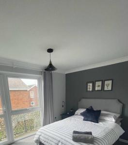 a bedroom with a bed and a large window at Waterside Villa in Corton