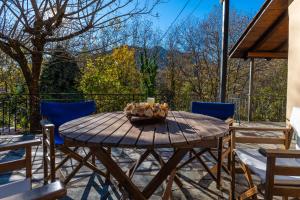- une table en bois avec des chaises et une bougie sur la terrasse dans l'établissement RiverHome, à Gávros
