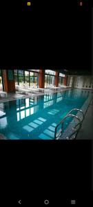 a large swimming pool with chairs in a building at studio unit whit pool and gym in Istanbul
