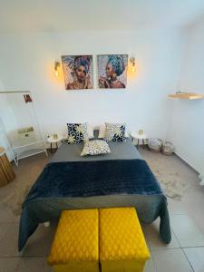 1 dormitorio con 1 cama grande y 2 cuadros en la pared en La Maison Ti Pòlwizyèn plage à 3 mn à pieds, en Port-Louis