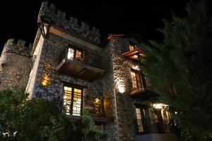 un gran edificio de piedra con ventanas por la noche en Pirgos Gerodimou, en Kalavrita