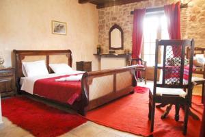 sypialnia z dużym łóżkiem i krzesłem w obiekcie Pirgos Gerodimou w Kalawricie
