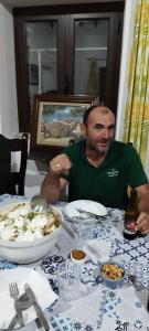 a man sitting at a table with a plate of food at Paisagem do Guadiana Turismo Rural in Odeleite