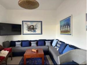 a living room with a couch and a table at Villa entière Dar Baida Plage David Bouznika in Bouznika