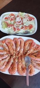 two plates of food with shrimp and vegetables on a table at Paisagem do Guadiana Turismo Rural in Odeleite