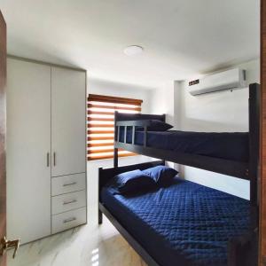 een slaapkamer met 2 stapelbedden en een kast bij Casa Familiar a Pasos del Mar Playa y Felicidad in Manta
