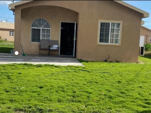 a house with a lawn in front of it at House of Bliss in Portmore