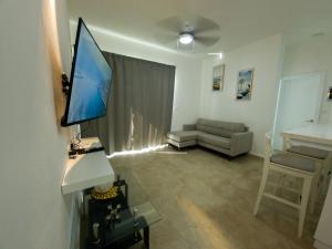 a living room with a television and a couch at 2JA Management Group - Condos White Hill in Sosúa